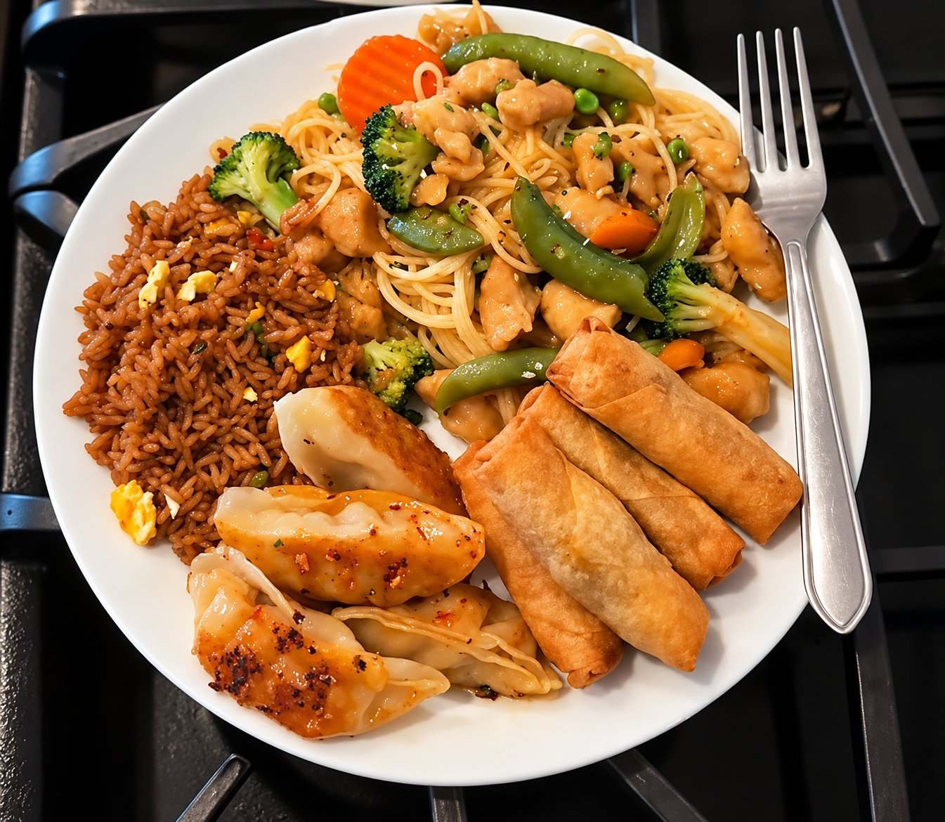 Asian inspired combo plate: fried rice, lo mein with chicken and vegetables, dumplings and spring rolls